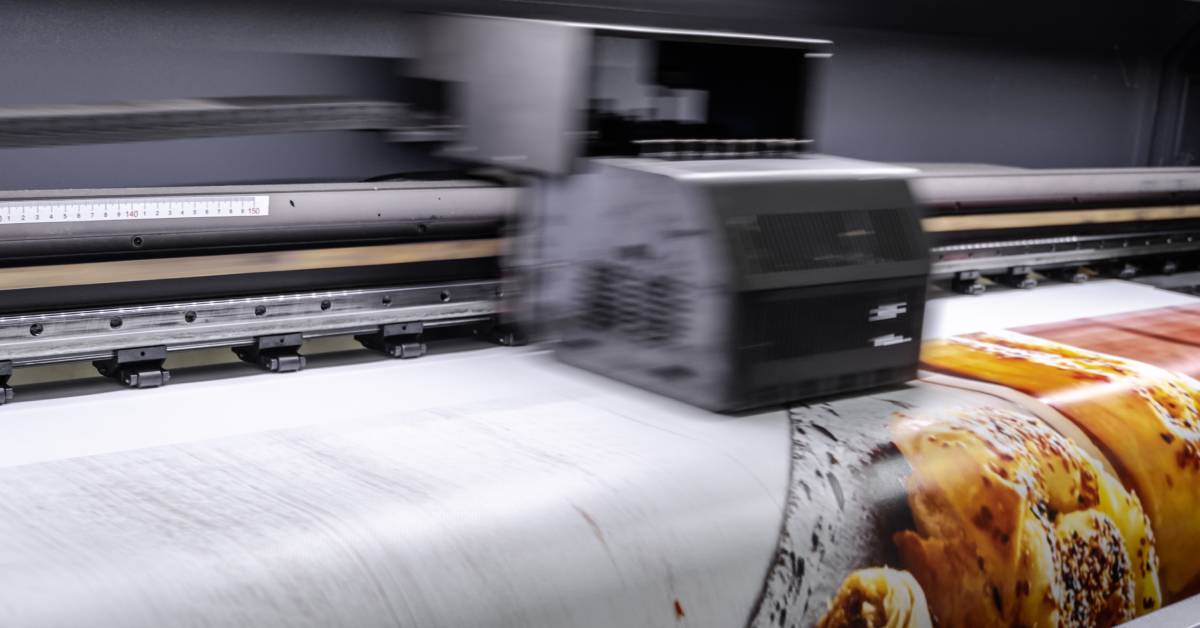 Floor plans and schematics are produced on large sheets of paper using the large-format printer set in front of them.