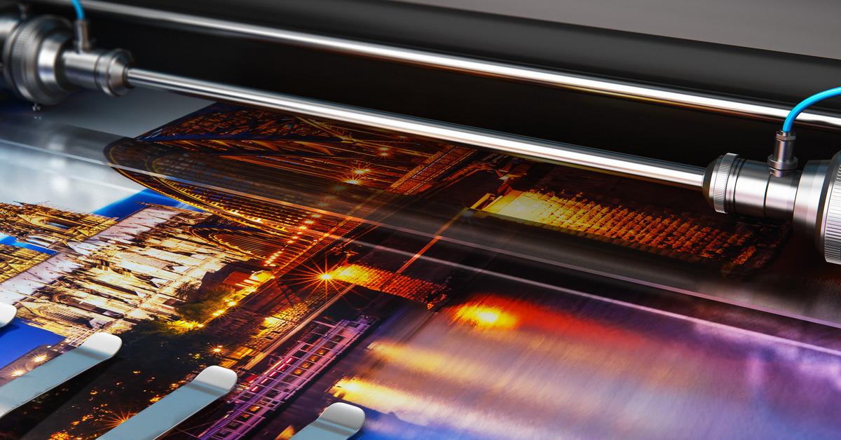 A large photo print develops from a plotter printer with great detail, showing a range of colors and textures.