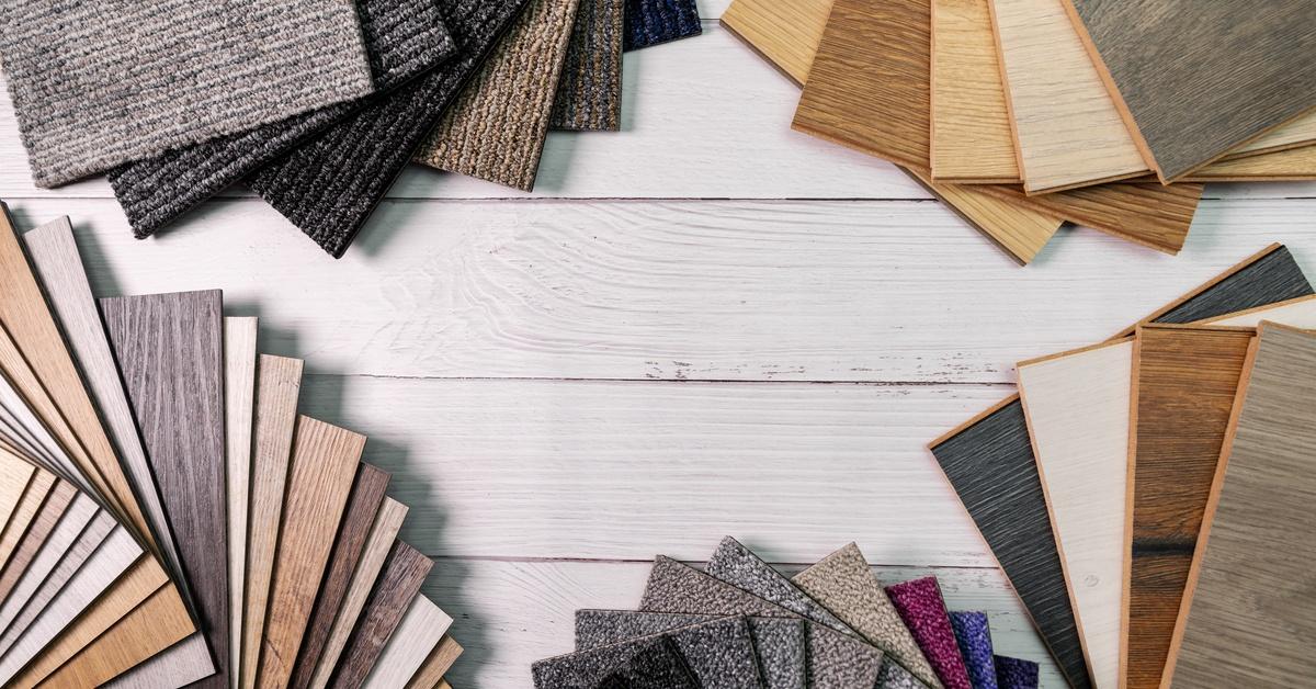 An organized collection of flooring sample squares, including carpet, wooden laminate, and vinyl tiles.